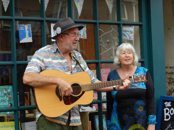 The Saga Louts, Hazel Underwood and Paul Watts, busking outside Crediton Community Book Shop. NP 210821 11