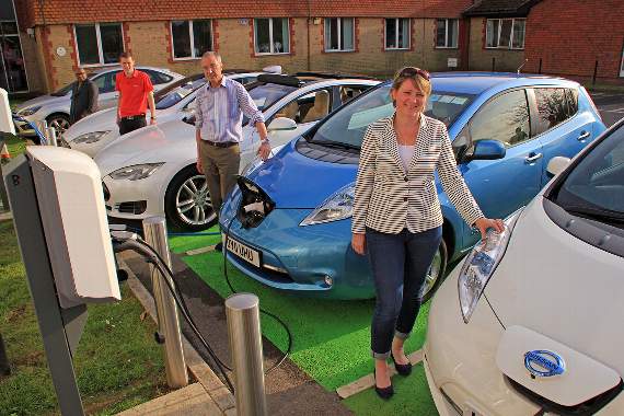 Soyful Haque and Will Soborune, of Tesla Taxis, look on as Mark Harvey and Elizabeth Garner charge their cars at Penns Place in Petersfield