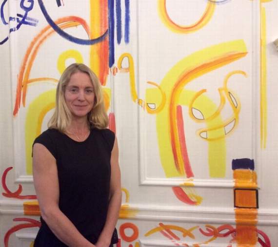 Alison McFadden in front of one of her murals at Wellington College