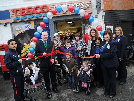 Farnham’s Deputy Mayor Mike Hodge cuts the ribbon with staff from Tesco and children and staff from The Ridgeway School