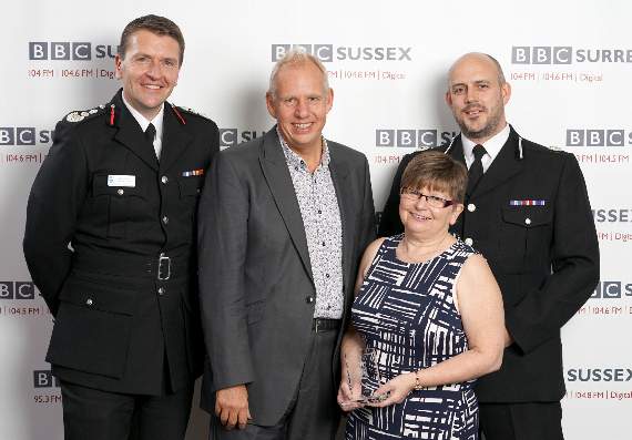 June Rasburn, with presenter Neil Pringle and the Chief Fire Officer of West Sussex Gavin Watts and the Assistant Chief Constable of Sussex Police Laurence Taylor