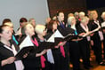 Choir sings while grant cash is handed out