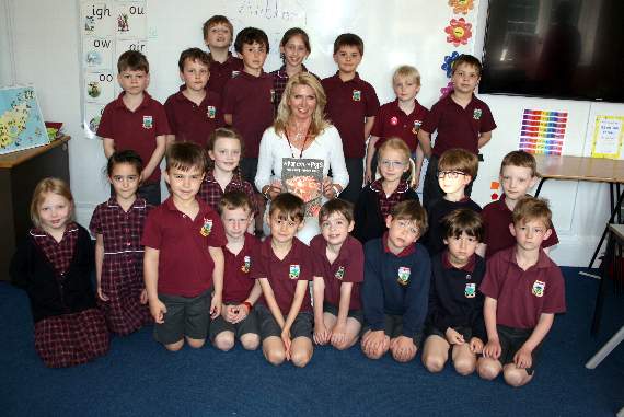 Andrea Prior (centre) with her book about pigs pictured with pupils from Barrow Hills, Witley