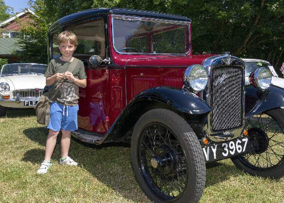 Camelsdale pupil Zack next to an 1933 Austin Seven one of the classic cars on show at the fete (HD28-292-18)