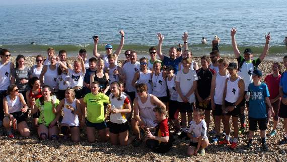 Runners and cyclists on the beach, having successfully completed the gruelling Race to the Beach challenge