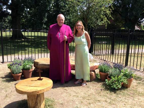 The Right Reverend David Williams, Bishop of Basingstoke, standing in the garden with headteacher Dawn Casson