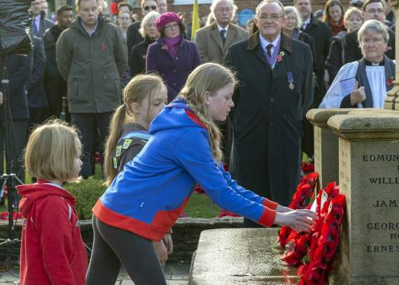 A Girl Guide lays a wreath during the ceremony watched by hundreds of people (HD47-469-18)