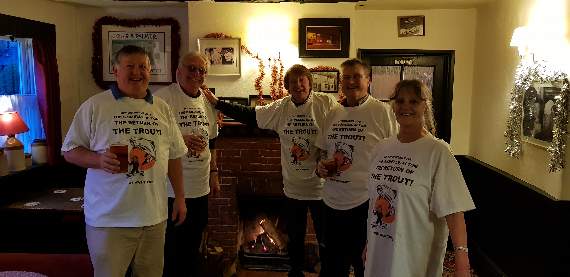 Raising a glass to Phil Troubridge (centre) in front of a roaring log fire