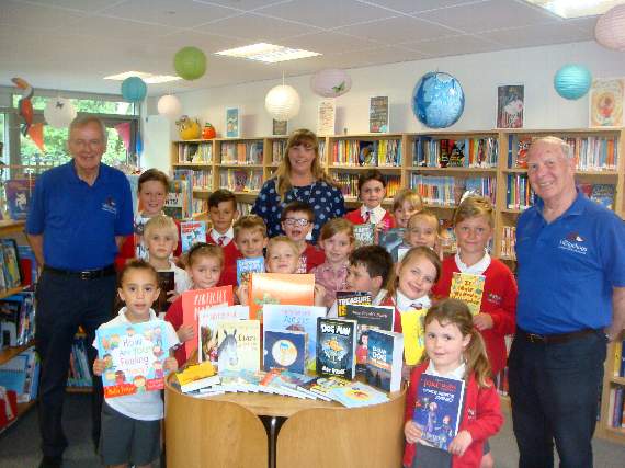 Members of The Hedgehogs and children from Potters Gate Primary School, with a selection of books bought thanks to the donation