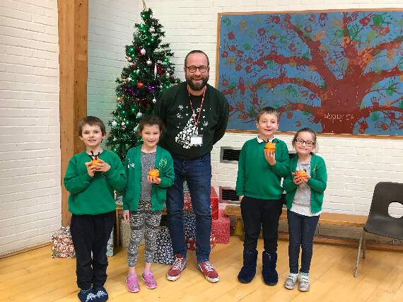 Children from Chestnut Class showed off their handmade Christingles with Vicar Dom Clarke