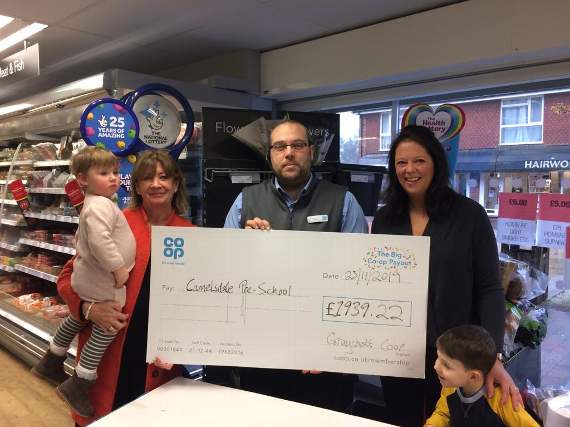 Camelsdale pre-school manager Fiona (left) and Molly with trustee Kat (right) and Freddy receiving their cheque from Ben at the Co-op