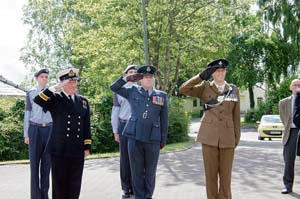 •Gary McKenzie of HMS Cambria, Rick Seager of the Royal Auxiliary Air Force and Andy Kuss of 1 Rifles salute the Armed Forces Day flag as it is raised.
