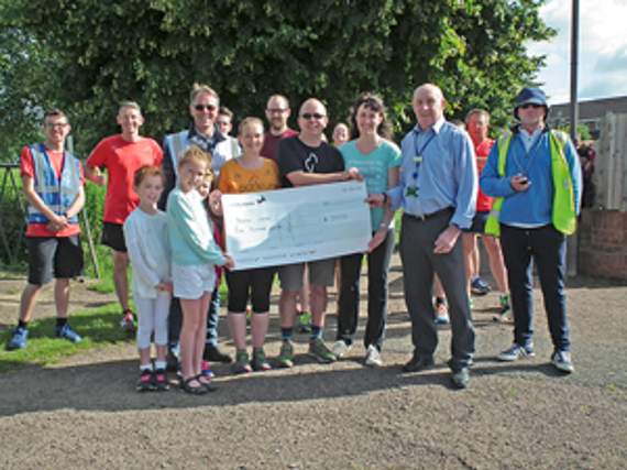 • Councillor Terry Hale presenting the cheque to the Lydney Parkrun volunteers.