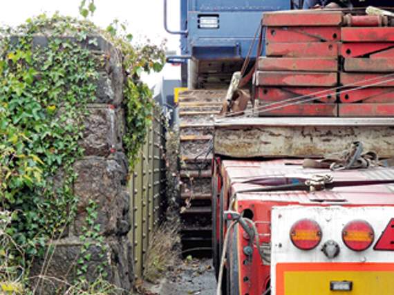 •Just inches to spare between the earthmover’s tracks and the side of the bridge.
