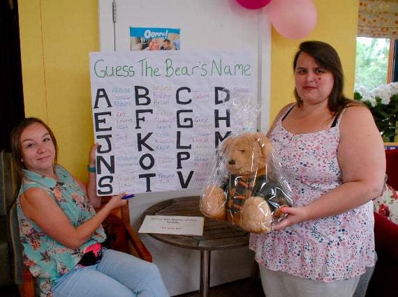 Staff member Kaylee Thomas with Laura Wood and a bear looking for a name.