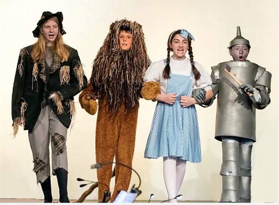 Off to meet the Wizard are Lily Salter as the Scarecrow, Wilfred Green as the Cowardly Lion, Connie Davies as Dorothy, and Ollie Taylor as the Tin Man.