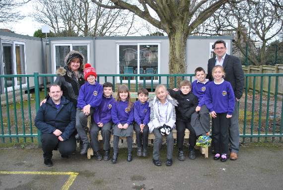 Ballasalla School pupils on the Friendship Bench with head teacher Jamie Cox and Carol and Rob Walmsley