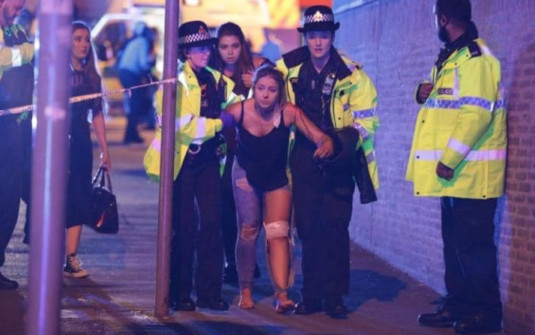 An injured concert-goer is led to safety from the Manchester Arena
