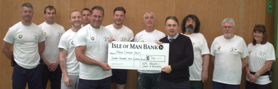 Senior Officer Mike Pacey (front left) and Deputy Prison Governor Nigel Fisher (front right) with the cheque surrounded by some of the staff members and prisoners who took part in the walk