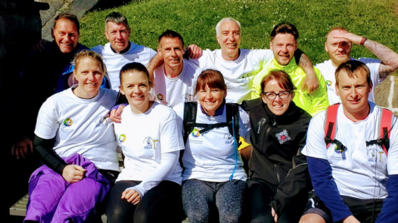 Senior Officer Mike Pacey (front left) and Deputy Prison Governor Nigel Fisher (front right) with the cheque surrounded by some of the staff members and prisoners who took part in the walk