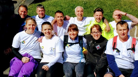 Senior Officer Mike Pacey (front left) and Deputy Prison Governor Nigel Fisher (front right) with the cheque surrounded by some of the staff members and prisoners who took part in the walk