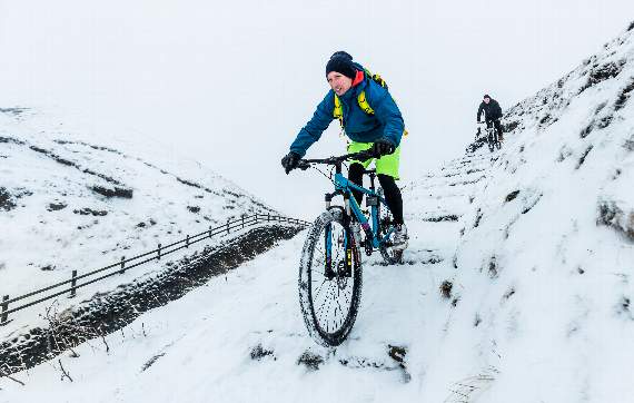 Cyclists near Mam Tor in the Peak District National Park, as snow and freezing conditions continue to hit the UK. PRESS ASSOCIATION