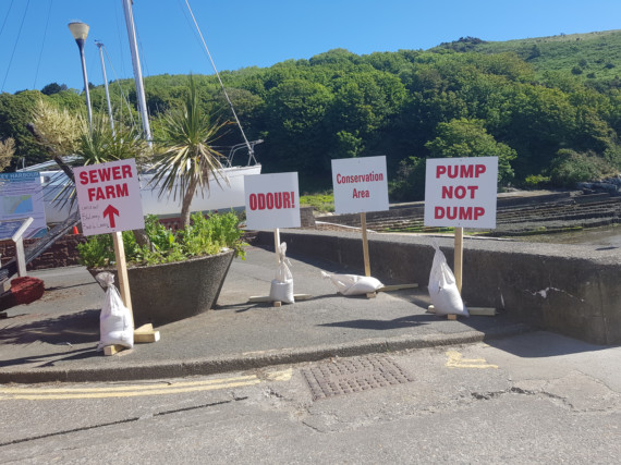 Signs opposing plans to erect new sewage treatment works in Laxey were spotted overlooking the proposed spot