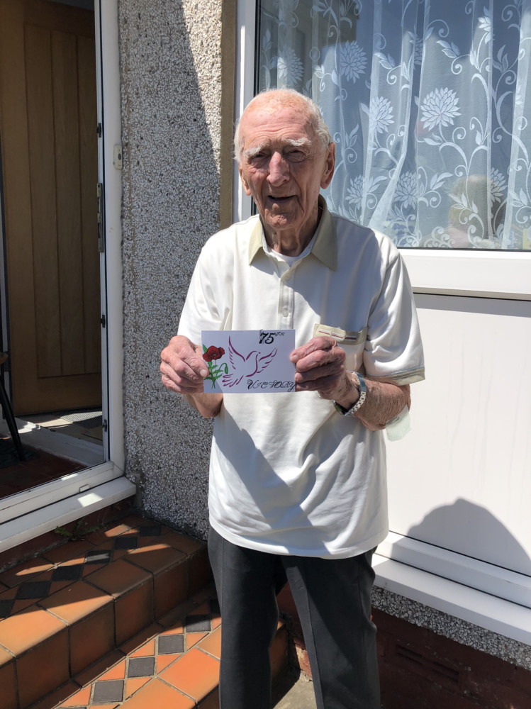 War veteran Hector Duff holding a card made by a students in France, which thanks veterans for their war efforts
