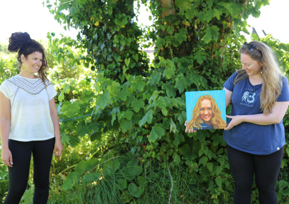 Artist Beth Louella (left) watches Manx midwife Bryony Manning admiring her NHS heroes portrait at a distance