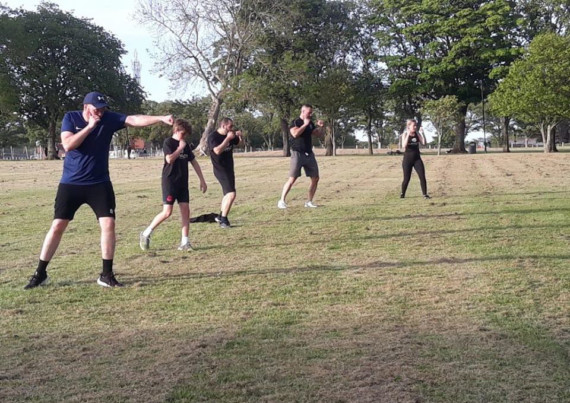 Members of Impact Kickboxing social distancing during an outdoor training session