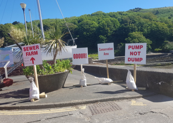 Signs opposing plans to erect new sewage treatment works in Laxey were spotted overlooking the proposed spot