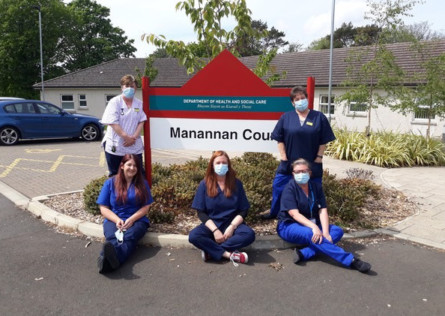NHS workers at Noble's Hospital don their scrubs made by stitchers from across the island