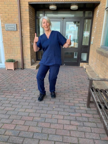 NHS worker Jackie looks pleased in her scrubs