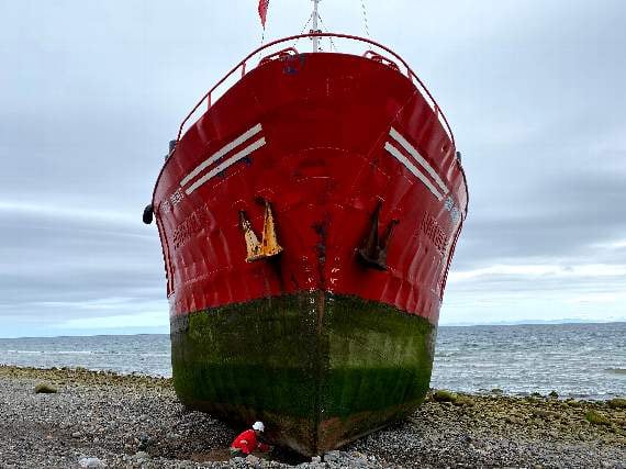A man with a shovel attempts to recover the boat