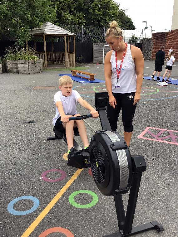 Paul Sharples on the rowing machine being helped out by Chloe Harvey from Astro to Atlantic.