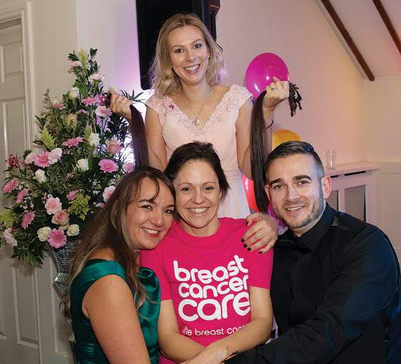 Amie is pictured with supporters, (and her donated hair) at the charity ball. Photo: John Newport