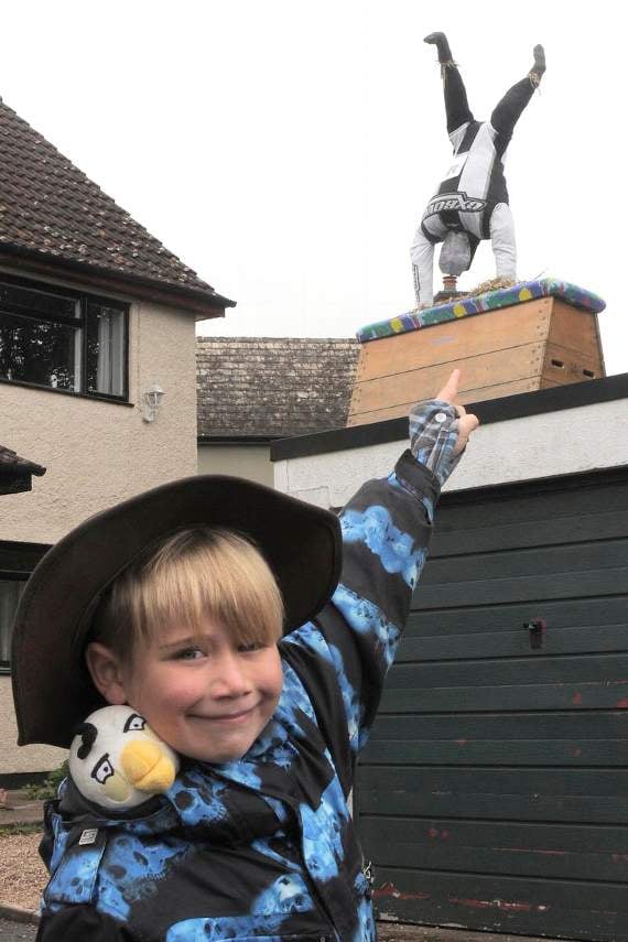 Gymnast Brereton Trim aged six, points to the scarecrow of himself somersaulting on the garage roof. Photograph by Martin Chainey Photography