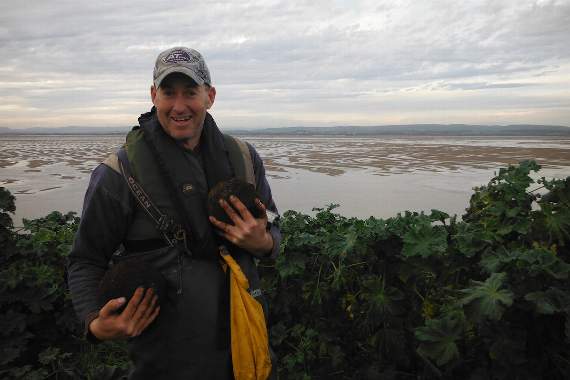 Richard Morgan with a couple of cannon balls found imbedded in the island side