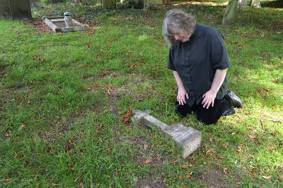 Reverend Jones next to the vandalised headstone of a 13-week-old baby girl