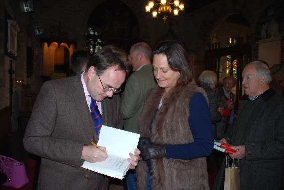 Quentin signs a copy of his book.