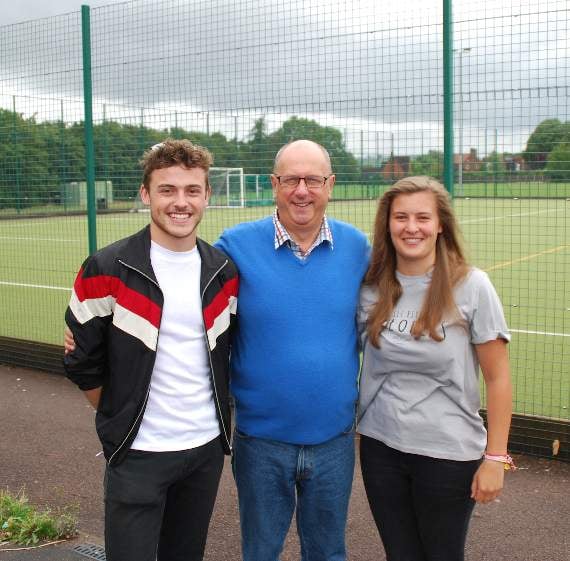 Headteacher Nigel Griffiths with the former Head Girl and Head Boy.