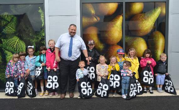 The Manager of the new Ross store, Jason Edwards, with children from Spring Gate Nursery School.