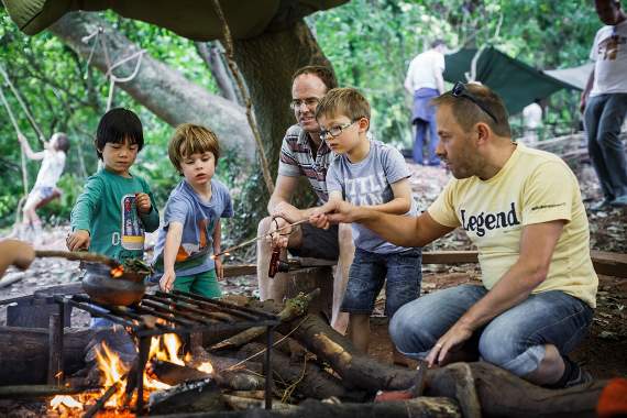 Dads and their children both enjoying campfire cooking at Dadfest.