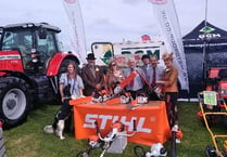 Kingsbridge Show chair and president try out chainsaws as they judge best trade stand