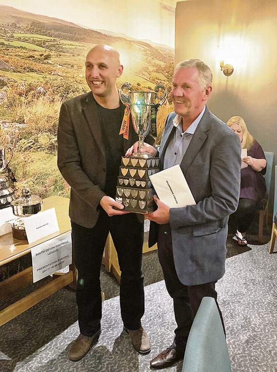 Phil Collings (right), Manager of Meadowbrook Athletic FC receiving the division 3 champions cup from Justin Osborne of league sponsors WBW Solicitors