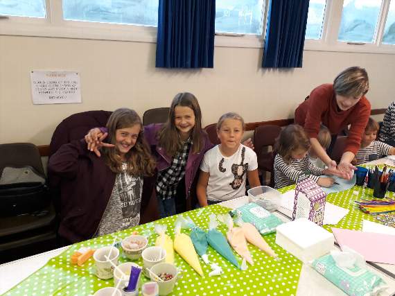 From left: Katy and Cara Macey and Bella Butler-Mogilski enjoying the cake decorating station