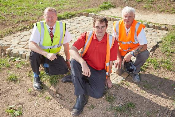 Archaeologist Chris Caine, who was involved in the dig, site manager Steve Smith and groundworker Phillip Lang on the Romansfield site with the newly reconstructed piece of the Roman road discovered at the site.
