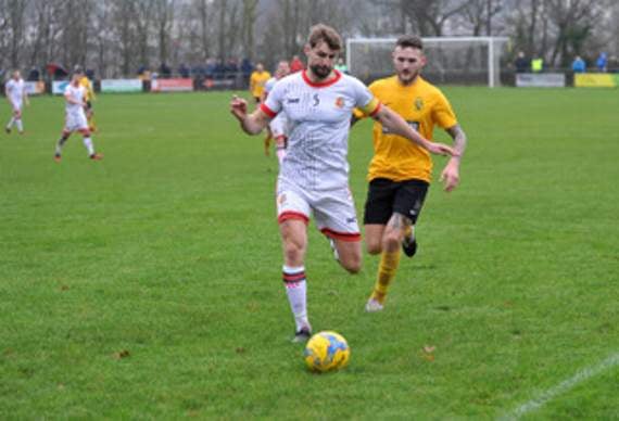 Tavistock skipper Lewis Daw is pressured by Buckland Athletic midfielder Nathan Cooper.