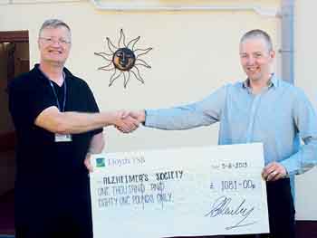 Adam is seen presenting the donation to Nigel Dufresnoy, of the Alzhemier’s Society.