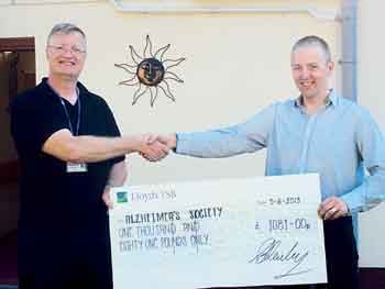 Adam is seen presenting the donation to Nigel Dufresnoy, of the Alzhemier’s Society.